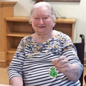 Lynn valley care centre, elderly woman displays Christmas ornament