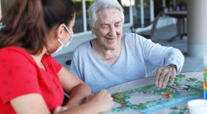 elderly lady and nurse making a puzzle together
