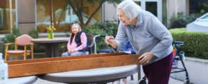 smiling senior woman playing games outdoor with a friend