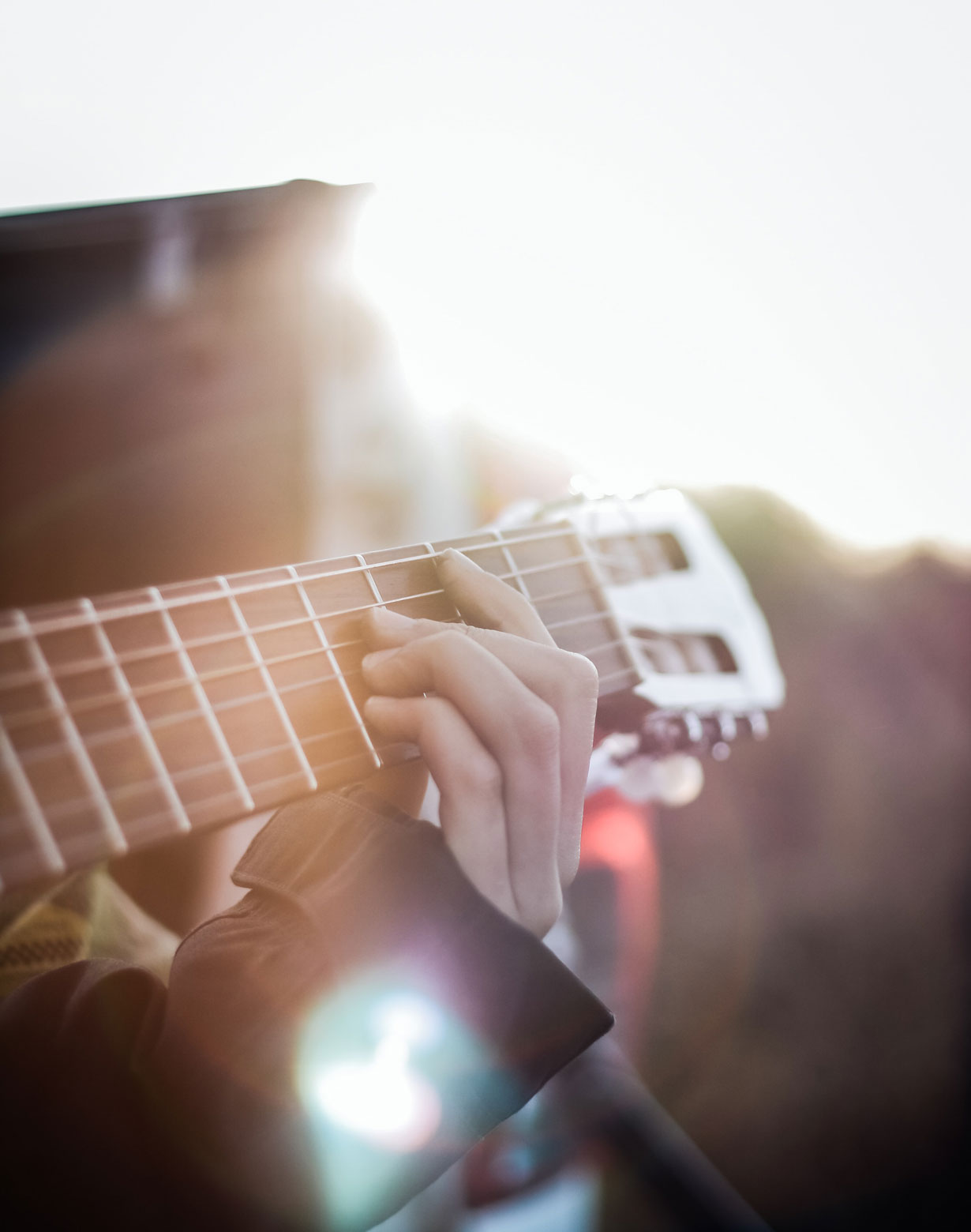 person playing guitar in the sun