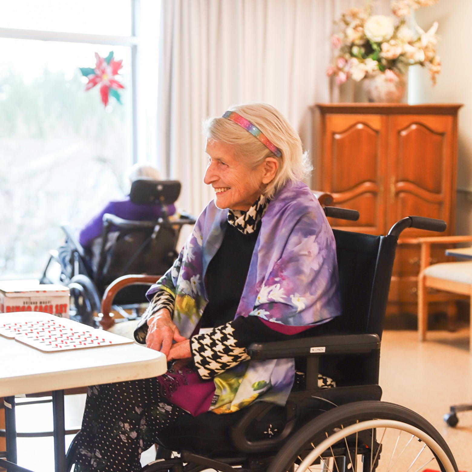 senior woman in care home playing game with friend