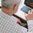 elderly man using laptop researching common scams for seniors