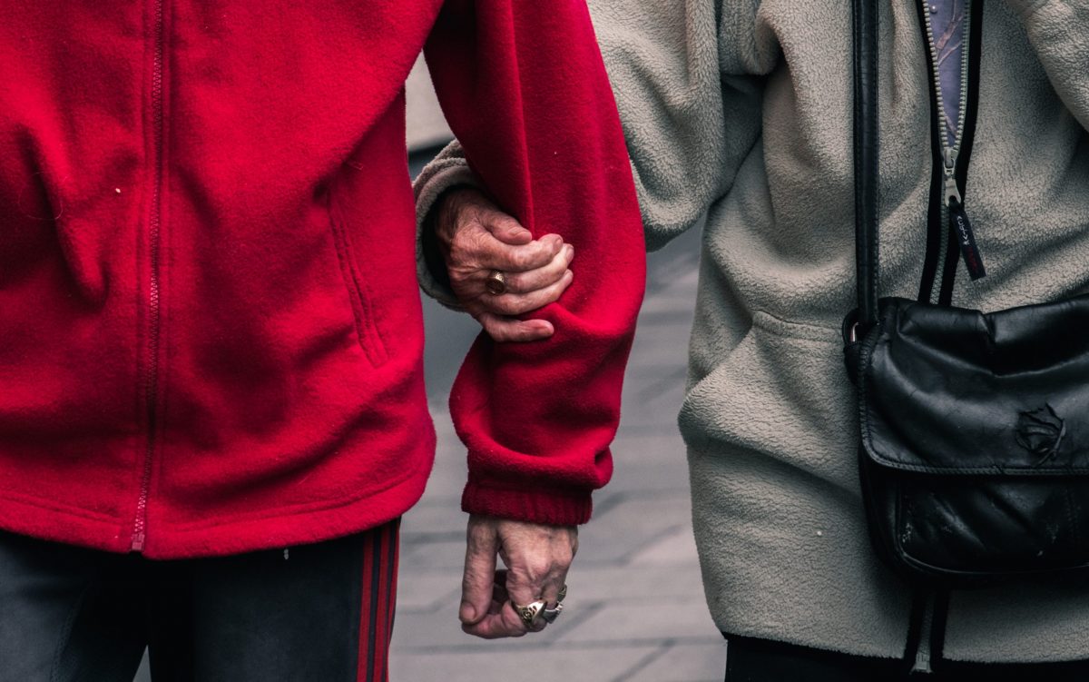 closeup of two seniors walking arm in arm